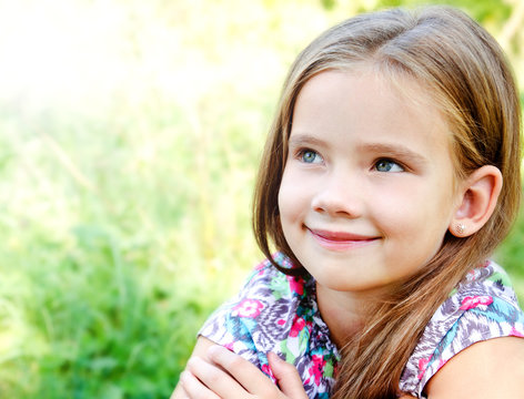 Portrait of adorable smiling little girl in summer day outdoor