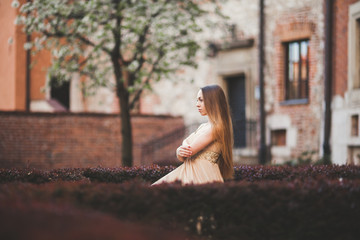 Beautiful happy woman in park a warm spring day sitting on the bench