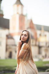 Fototapeta premium Girl in luxurious long dress on street of old town