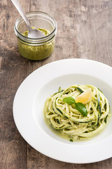 Zucchini noodles with pesto sauce on wooden table

