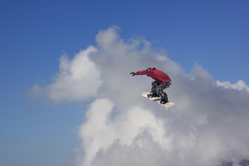 Naklejka na ściany i meble Snowboarder jumping on mountains. Extreme sport.