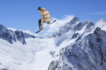 Naklejka na ściany i meble Snowboarder jumping on mountains. Extreme sport.