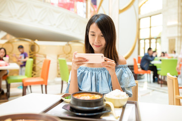 Woman taking photo on mobile phone before having the meal