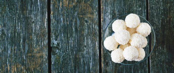 Panorama. Coconut balls on a wooden background. Menu. Banner.