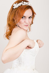 Fototapeta premium red-haired bride in a wedding dress, bright unusual appearance. Beautiful wedding hairstyle and bright make-up