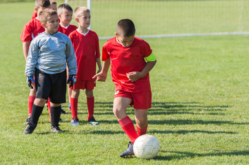 Obraz premium Boys playing football soccer game on sports field