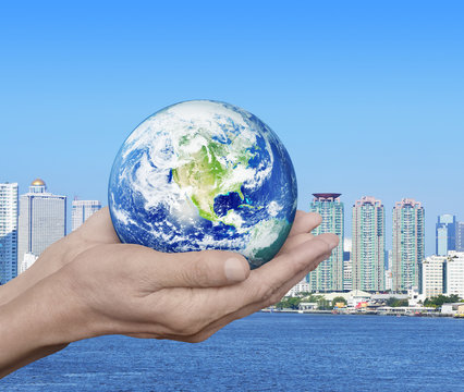 Earth in hands over city tower and river background, Environment
