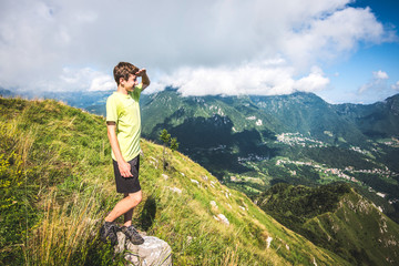 Naklejka na ściany i meble holidays in mountain - boy contemplate the view
