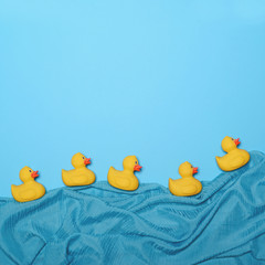 Five rubber ducks swimming in lake made of waving silk - Trendy
