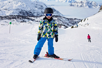 Cute little boy, learning to ski in Austrian ski resort