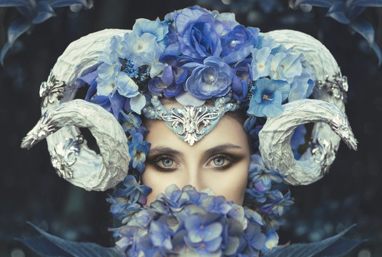 Woman with goat horns and blue flowers