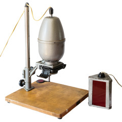 Darkroom equipment - retro photographic enlarger and red lamp  on white background