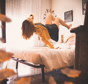 Unrecognizable woman levitates above the bed