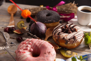 fresh donut with coffee on wooden table with napkin, spoon and cherry