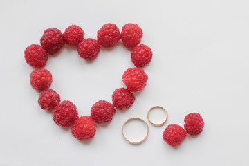 wedding card with a heart of raspberry and golden rings