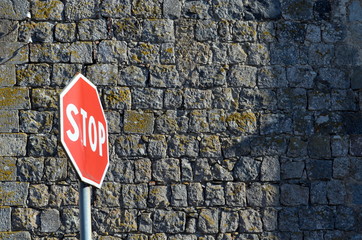 Stopschild vor alter Mauer