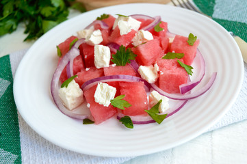 Dietary salad from fresh watermelon, blue onion and goat cheese (feta). Close up