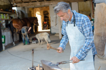 Farrier shaping horseshoe