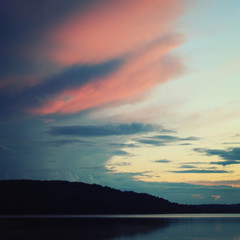 Pink shades of sunset on the clouds. Aged photo. Kenozero lake on a late evening. Nature of Russian North. Kenozersky National Park (UNESCO Biosphere Reserve), Russia.