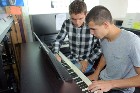 Two young men playing an organ
