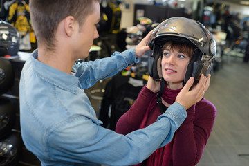 woman trying on a motorcycle helmet