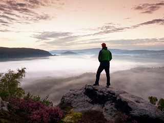 Tourist man on rock empire  is watching over creamy foggy morning valle