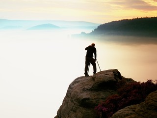 Obraz premium Professional use mirror camera and tripod on peak of rock