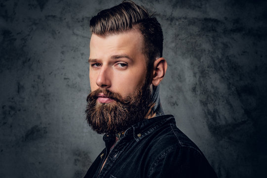 Bearded male in black shirt with tattoo on his neck.