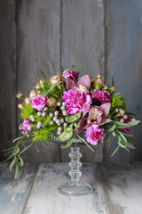 Floral arrangement with orchids, carnations and brunia flowers