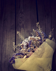 Bouquet of dried flowers on wooden background.