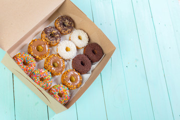 Donuts in box on wooden table. Top view