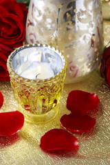 Golden candle holder and red roses, elegant wedding decoration.