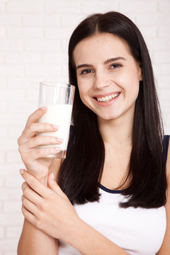 Happy young woman drinking milk