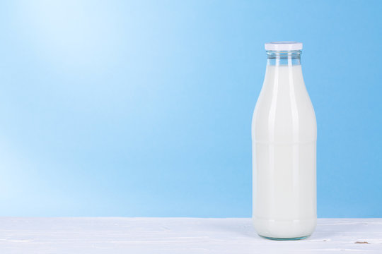 Flasche Milch auf hell blauem Hintergrund.