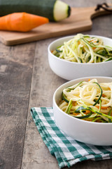 Carrot and zucchini noodles on a rustic wooden table

