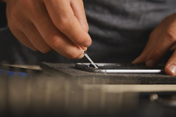 Using hands to remove battery glue from opened smartphone to replace and fix it with new one