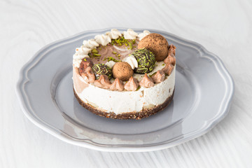 Raw vegan cake with lime, banana and chocolate, decorated with lime zest and chocolate balls. 