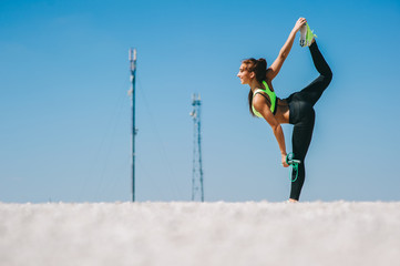 beautiful girl in a suit making a balance on one leg