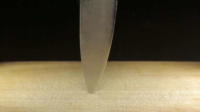 Large sharp knife stuck in wooden desk