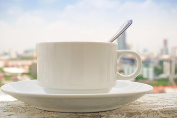 Coffee cup placed on the building in the morning.