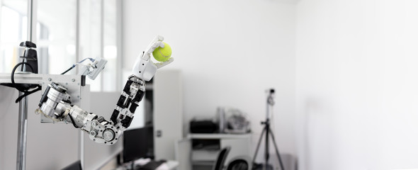 mechanized robot hand holds the objects drawn a tennis ball