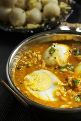 Egg curry served with steamed rice dumplings, selective focus