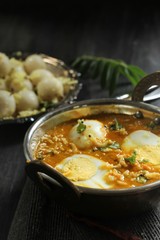Egg curry served with steamed rice dumplings, selective focus