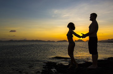 Fototapeta premium Silhouettes loving couple at sunset on the Philippine Islands
