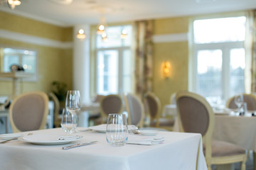 Empty glasses and plates installed in the restaurant, the restaurant served table, white tablecloth...