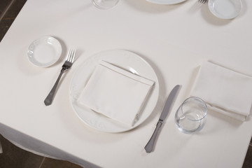 served table restaurant wine being poured into glass, white tablecloth, plates and cutlery