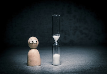 Deadline symbol with small figure watching hourglass countdown. Concept of time pressure, aging alone and business pressure. - obrazy, fototapety, plakaty