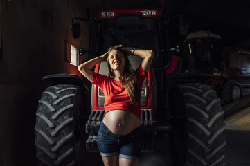 Fototapeta na wymiar pregnant next to a woman harvesting machine