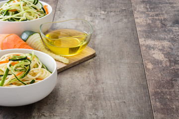Carrot and zucchini noodles on a rustic wooden table
