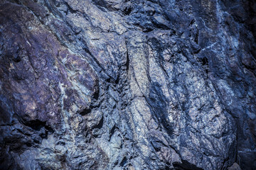 Stone background, rock wall backdrop with rough texture. Abstract, grungy and textured surface of stone material. Nature detail of rocks.
